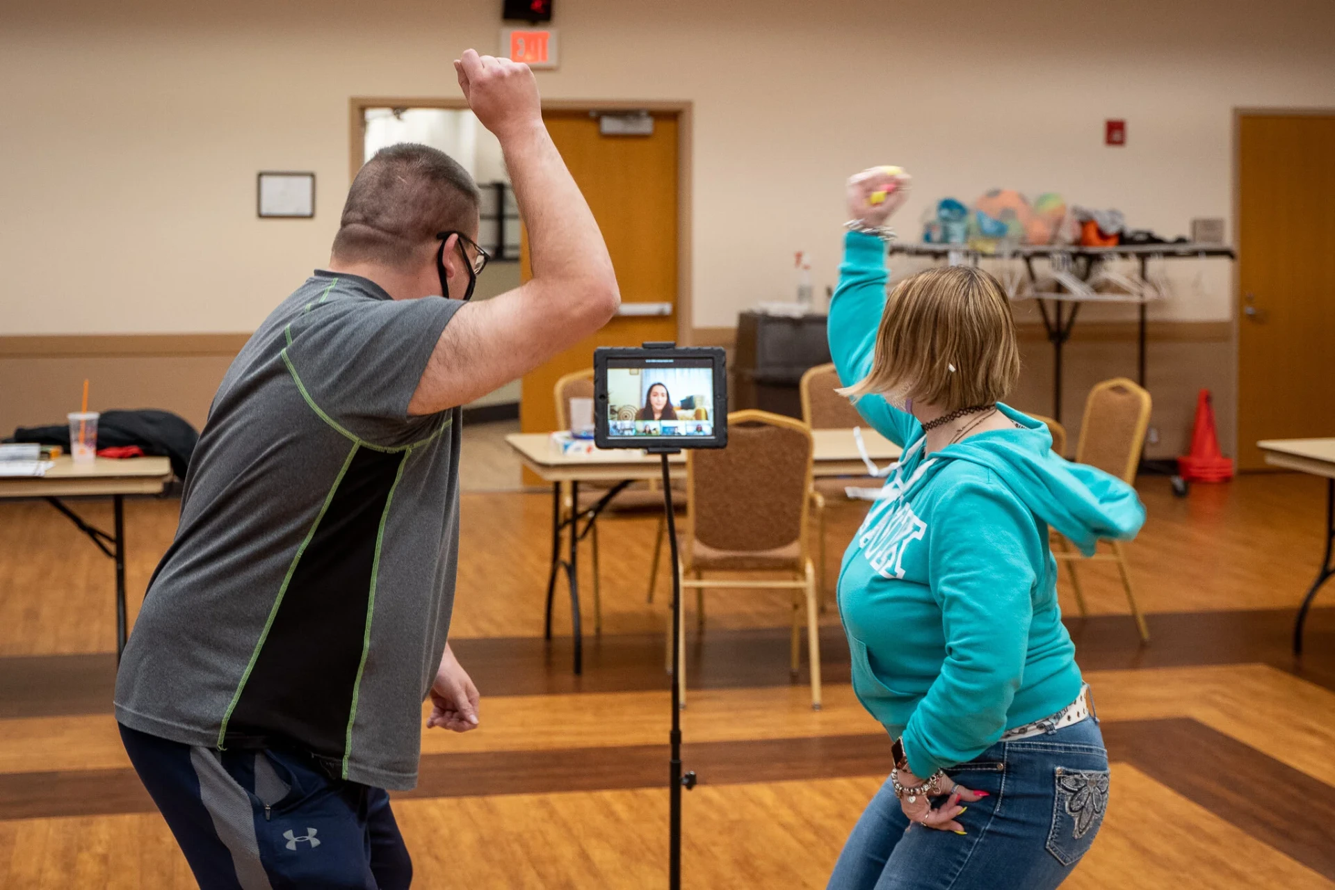 Two participants dancing side by side in front of the tablet